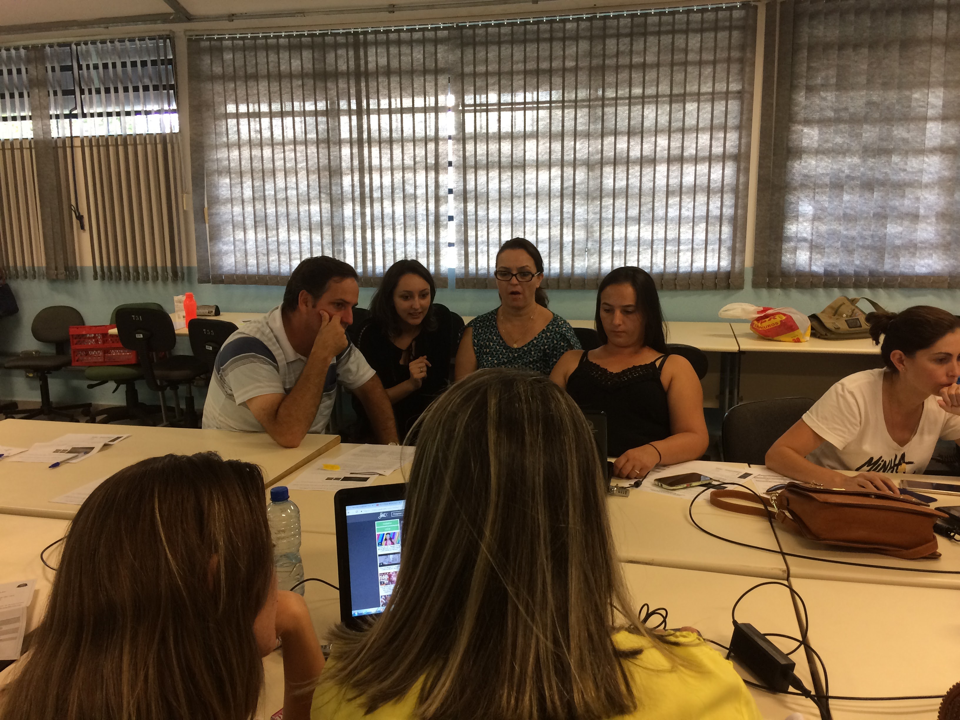 Cena da sala de aula com o professor na frente da aula de ciências